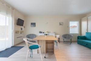 Un comedor y una sala de estar con mesa y sillas. en Manava, en Vaux-sur-Mer