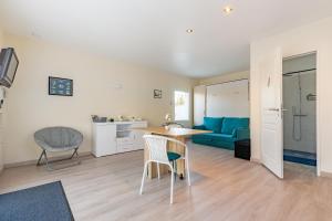 Una sala de estar con una mesa y sillas y un sofá. en Manava, en Vaux-sur-Mer 8 fotos más