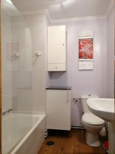 Un baño blanco con inodoro y lavabo. en Casa Montse-Izquierda, en Colombres