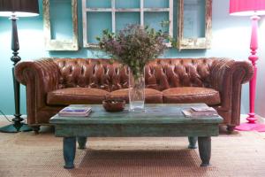 巴塞罗那维奥莱塔精品酒店的客厅里一张棕色皮沙发,配有桌子