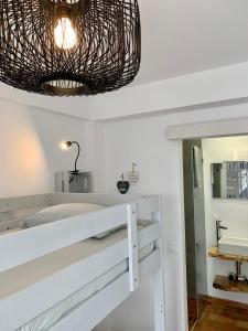 bagno con pareti bianche e grande specchio di Almograve Beach Hostel ad Almograve