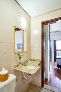 a bathroom with a sink and a mirror at Charmoso apto a 200 m da rua mais turistica da cidade c Wifi e garagem in Ubatuba