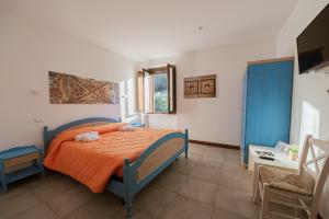 a bedroom with a bed with an orange bedspread at Locanda Orvieto Agriturismo in Orvieto