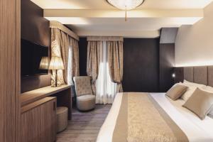 a hotel room with a bed and a chair at Hotel Aquarius Venice - Ascend Collection in Venice