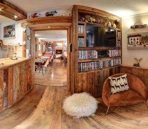 a living room with wooden floors and a book shelf at Hôtel Les Cimes in Megève