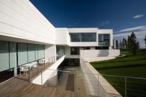 a large white house with a wooden deck at Finca Prats Hotel Golf & Spa in Lleida