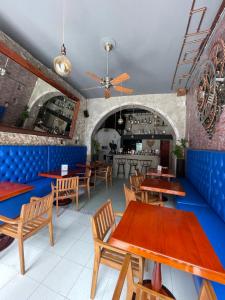 a restaurant with wooden tables and blue booths at Hotel Mangata in Cartagena de Indias
