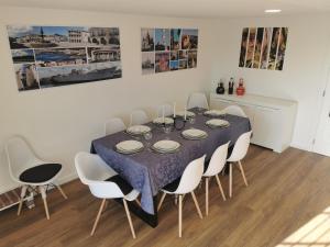 a dining room with a table and white chairs at VIVENDA TABORDA in Viana do Castelo