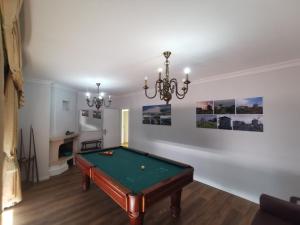 a pool table in a living room with a chandelier at VIVENDA TABORDA in Viana do Castelo