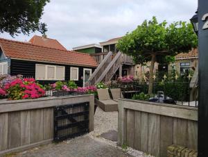 una casa con una valla de madera y algunas flores en 't Maerhus, en Hindeloopen