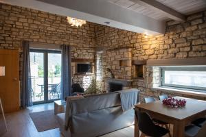 a living room with a table and a stone wall at Kalpaki luxury maisonette 3 in Elaía