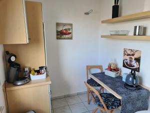 eine kleine Küche mit einem Tisch und Stühlen in einem Zimmer in der Unterkunft Airport Apartments Valentina in Meckenbeuren