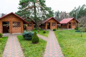 a row of wooden cottages in a yard at Приозерний заїзд in Rulevo