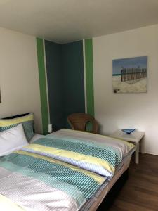 um quarto com uma cama com riscas verdes e brancas em Tarrazza Ferienwohnungen Erpeldinger em Ellenz-Poltersdorf