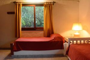 ein Schlafzimmer mit zwei Betten und einem Fenster in der Unterkunft El jagüel in Villa General Belgrano