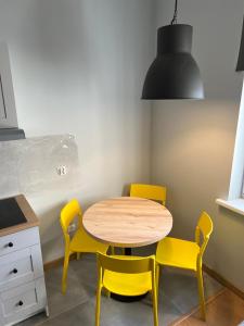 a kitchen with a table, chairs and a lamp at Plac Katarzyny 13 in Toruń