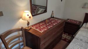 1 dormitorio con escritorio, lámpara y espejo en Casa Vacanze: Maison Des Gnomes, en Challand Saint Anselme