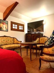 a living room with a tv and a table and chairs at Eden Cottage in Saint Gatien des Bois