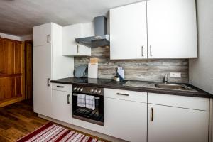 a kitchen with white cabinets and a sink at Rainerhof in Murau