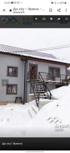 Una foto de una casa con nieve delante. en Дух лісу en Yaremche