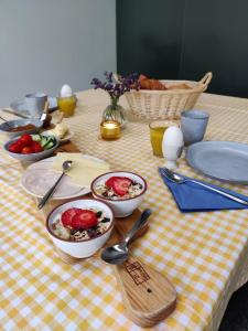 a table with bowls of food on a checkered table cloth at Chambres d'hôtes / B&B Chez Mon Rêve in Éguzon-Chantôme