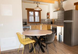 a kitchen with a table and chairs and a refrigerator at Balcón de Pineta in Bielsa