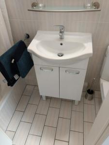 a bathroom with a white sink and a tiled floor at Ruhige, gemütliche 1-Zimmer Gartenwohnung für 2 Erwachsene in Lübeck