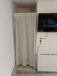 a white curtain in a room with a tv at Ruhige, gemütliche 1-Zimmer Gartenwohnung für 2 Erwachsene in Lübeck