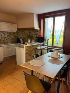 a kitchen with a wooden table and chairs in a kitchen at Le moulin Bertrand in Martigny-Courpierre