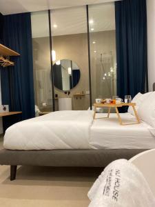 Un dormitorio con una cama grande y una mesa. en Nu House Rooms & Apartments, en Cassano delle Murge
