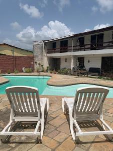 two chairs sitting in front of a swimming pool at Chalé em Nossa Senhora da Conceição in Paulista
