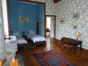 a living room with blue walls and a bed and a table at Château de Souesmes in Souesmes