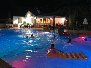 a group of people in a swimming pool at night at Alessandro in Sidari