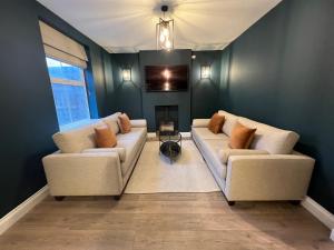 sala de estar con 2 sofás y chimenea en Luxury Cromer cottage with hot tub & log burner in Town, en Cromer