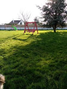 a red picnic table in a field of green grass at À La Maison Du Bonheur in Audruicq