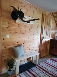 Zimmer mit einer Holzwand mit einer Bank und einem Hut in der Unterkunft Rainerhof in Murau