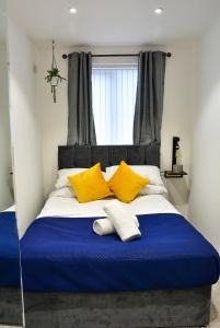 a bedroom with a large bed with yellow pillows at Skyline hanover free parking in Swansea