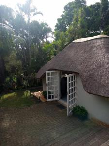 ein strohgedecktes Haus mit einem Strohdach in der Unterkunft Montrose Valley B&B in East London