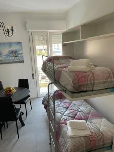 - une chambre avec 2 lits superposés et une salle à manger avec une table dans l'établissement Appartamento Torre Matilde, à Viareggio