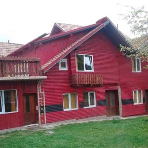 a red house with a gambrel roof at Pensiunea Irina 3 in Zărneşti