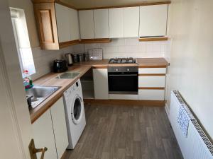 une petite cuisine avec des placards blancs et un lave-linge dans l'établissement Flat 4 Cleethorpes apts, à Cleethorpes 7 autres photos