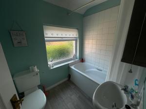 a bathroom with a toilet and a sink and a tub at Flat 4 Cleethorpes apts in Cleethorpes