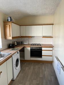 a kitchen with white cabinets and a dishwasher at Flat 4 Cleethorpes apts in Cleethorpes