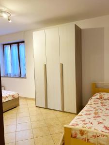 1 dormitorio con armarios blancos y suelo de baldosa en Domo sa Funtana, en Olmedo