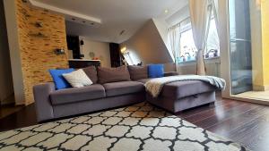 a living room with a gray couch and blue pillows at APARTAMENT 202 in Giżycko