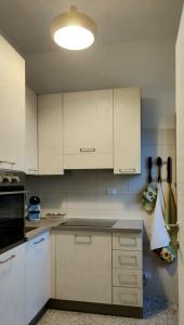 a kitchen with white cabinets and a stove top oven at Masseria Parco delle Casette in Alberobello