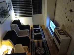 a living room with two chairs and a flat screen tv at Dučić Apartment in Trebinje