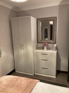 1 dormitorio con armario blanco y espejo en Machrie Cottage, Oban,, en Oban