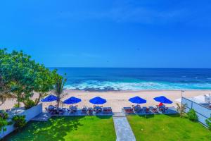 an aerial view of a beach with blue umbrellas at Amanda Beach Villas in Unawatuna