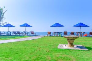 a bird bath with chairs and umbrellas on the beach at Amanda Beach Villas in Unawatuna